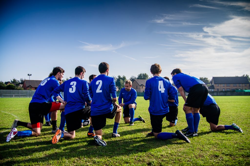 Les 11 joueurs de l'équipe de football partagent et discutent de leur stratégie. Ils représentent une équipe soudée.
